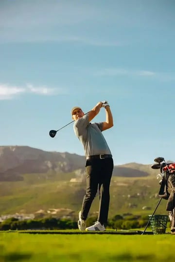 Golfer Swinging with Mountain Background